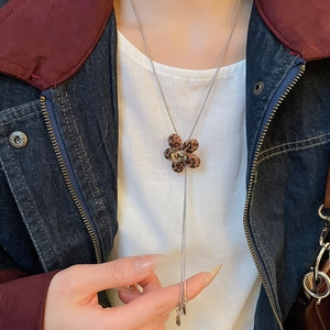 Detail of leopard print flower pendant necklace with square crystal and silver snake chain