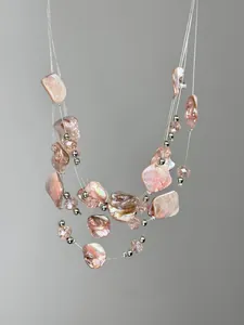 Detail of pink irregular crushed stone beads and pearls on multilayer necklace