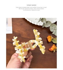 Detail of marble acetate flower hair claw with durable metal spring and rhinestone inlay