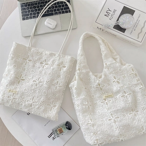 Détail du sac cabas en dentelle blanche avec broderies florales et motifs ajourés chic