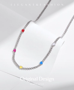 Detail of s925 silver choker necklace with colorful heart charms on a white background