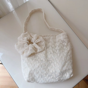 Detail of floral lace embroidery on cream cotton tote bag with matching hair scrunchie