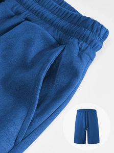 Detail view of blue men's drawstring sweat shorts with elastic waist and knit texture