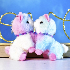 Pair of colorful pastel alpaca plush keychains with pearl necklace and metal rings.