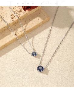 Detail of S925 silver necklaces with royal blue faceted gemstone pendants on stone decor