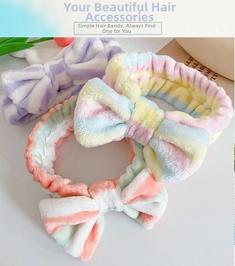 Close-up of three macaron-colored fuzzy bow headbands with soft coral fleece texture