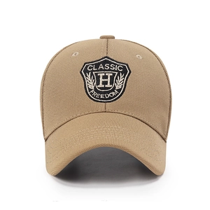 Khaki structured baseball cap featuring gold H letter embroidery and shield patch design