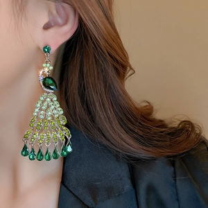 Detailed view of peacock tassel earrings with green crystals and sparkling stones