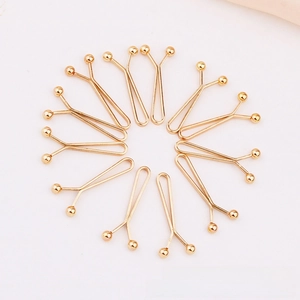 Close-up of ten gold U-shaped metal scarf clips arranged in a circular pattern on white