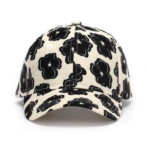 Detailed close-up of a floral print baseball cap with cream canvas and black flower motifs