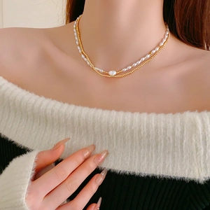Double-layered necklace with rice pearls, gold beads, and a baroque pearl centerpiece