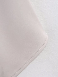 Close-up of high-quality stitching and light pink fabric texture on a strapless dress