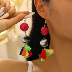 Bohemian multilayer tassel earrings with colorful woven balls on female model