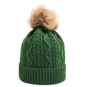 Detailed view of forest green cable knit texture and fluffy faux fur pompom on beanie