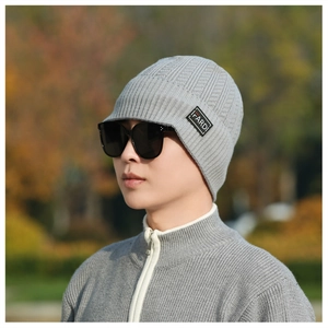 Detail of gray knitted beanie with brim featuring a rectangular textile i-FARDI brand label