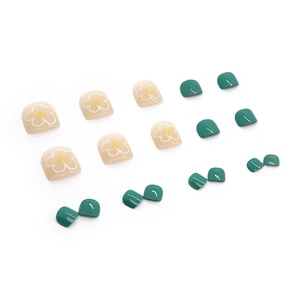 Press-on toenails in dark green and yellow with white daisy floral patterns