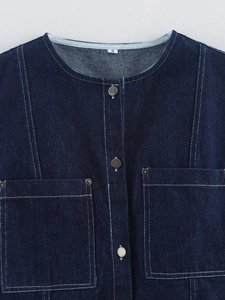 Detail of dark blue denim sleeveless top with metal buttons and stitched seams