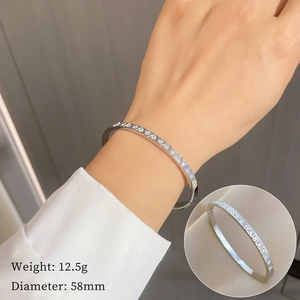 Minimalist silver titanium steel bangle with cubic zirconia on a female wrist