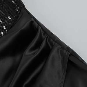 Macro des paillettes scintillantes et de la texture satinée lisse de la robe noire