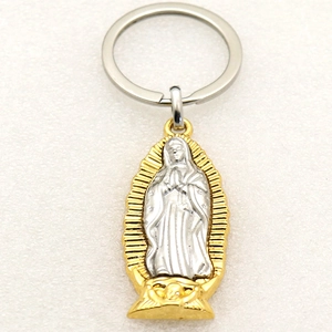 Detail of bicolored metal keychain featuring a silver Virgin Mary pendant in a gold frame