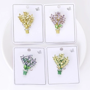 Macro detail of wheat ear brooches with colorful rhinestones on white card