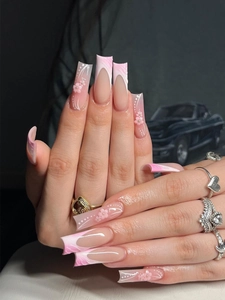 Macro shot of French gradient press-on nails with 3D floral details and white accents