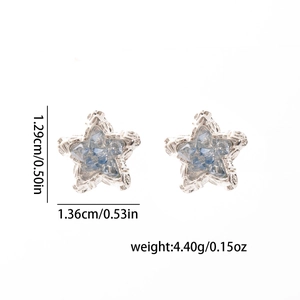 Star-shaped earrings with blue crystals and measurement specs of 1.29cm by 1.36cm