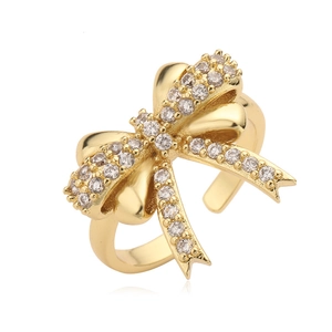Adjustable gold bow ring with sparkling zircon stones on a clean white background