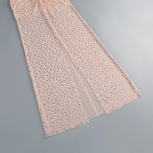 Détail d'une robe de soirée en résille rose avec paillettes et fente haute