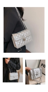 Detail of silver quilted crossbody bag featuring metal chain and sleek square shape