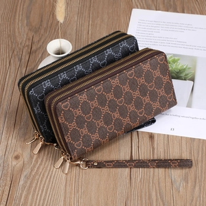 Dual-zip long wallets in brown and black with embossed logo patterns and wrist straps