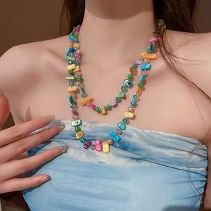 Détail d'un collier bohème à plusieurs rangs avec perles de résine et éclats de coquillages