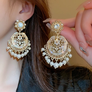Vintage palace style gold earrings with white pearls and champagne rhinestones on model