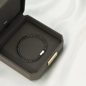 Macro detail of black tennis bracelet with 5A cubic zirconia and silver buckle on silk