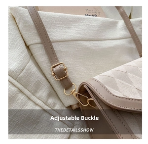 Detail of beige quilted shoulder bag showing golden metal buckle and leather strap