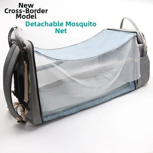 Detail of grey diaper bag expanding into a travel cot with mesh mosquito net