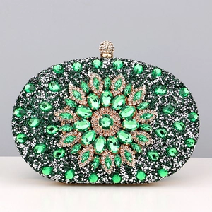 Detailed view of dark green rhinestones and emerald flower pattern on evening bag