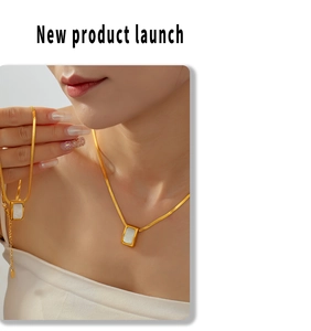 Detail of gold flat blade chain and white rectangular shell pendant on the necklace