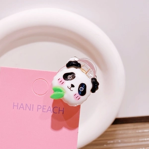 Detailaufnahme einer Panda-Haarklammer mit Bambusblatt auf einer rosa Schmuckkarte