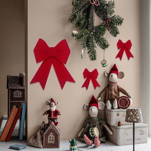 Close-up of three red velvet Christmas bows used as indoor holiday hanging decorations