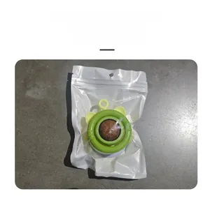 Close-up of a wall-mounted catnip ball toy in green and yellow plastic packaging