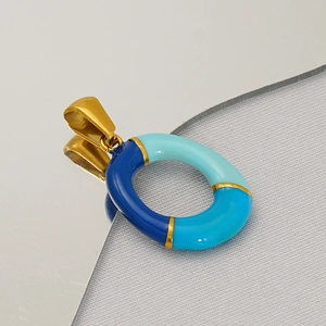 Macro detail of oval titanium steel letter pendant with colorful blue enamel finish