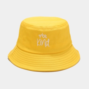 Detailed view of white be Kind embroidery on a vibrant yellow cotton bucket hat