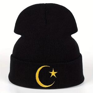 Close-up detail of moon and star embroidery on black knitted winter beanie hat