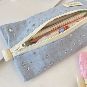 Macro shot of the blue star-patterned pencil case interior and its silver metal zipper