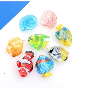 Macro view of colorful acrylic tropical fish and shell hair clips in various sea styles