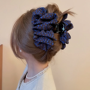 Détail d'une grande pince à cheveux en tissu imprimé léopard dans un chignon élégant de dos