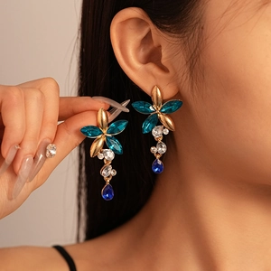 Vintage floral jewelry set with blue rhinestones and tassels worn by a model