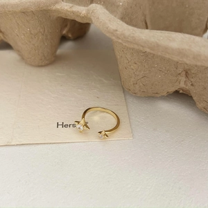 Detail of adjustable gold star ring with micro-pave cubic zirconia on white paper