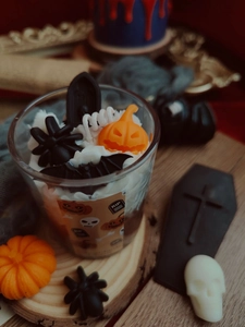 Close-up of Halloween soy wax candle with spider, pumpkin, and bat decorations